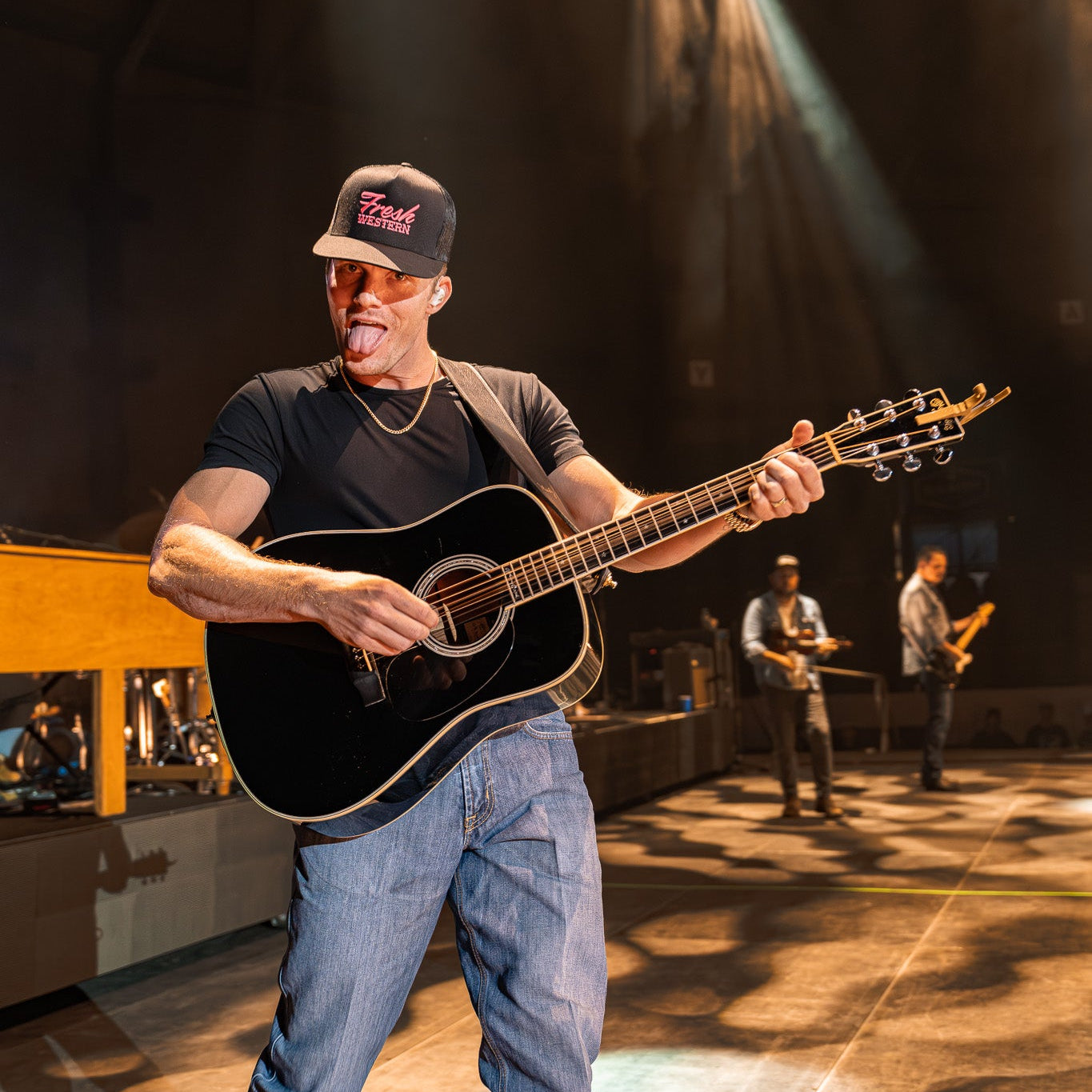 Parker McCollum playing guitar on stage wearing Fresh Western Black Country Tour Hat with Hot Pink Embroidered Logo