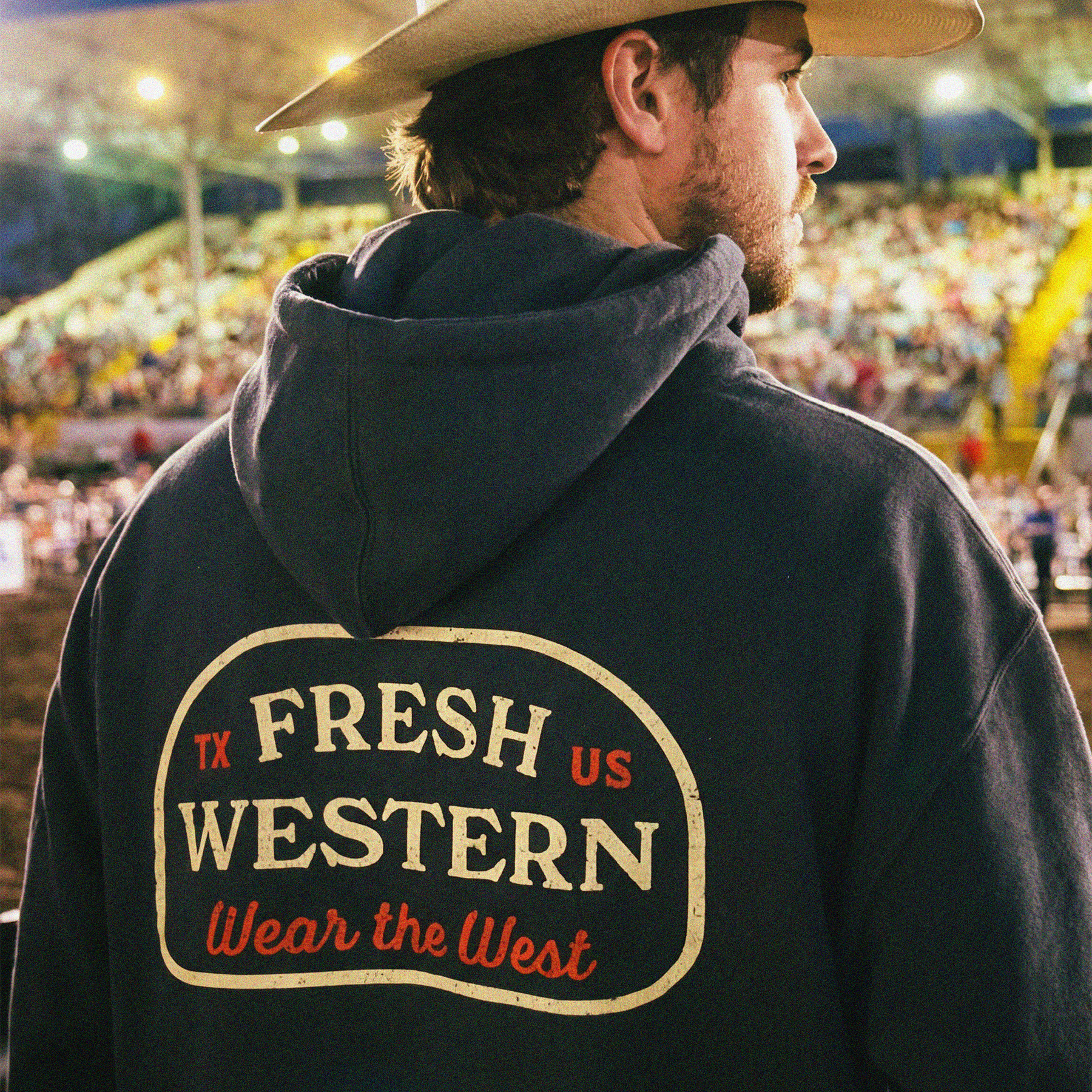 Fresh Western Charcoal Grey Hoodie on Cowboy at Rodeo. Hoodie features Wear the West motto