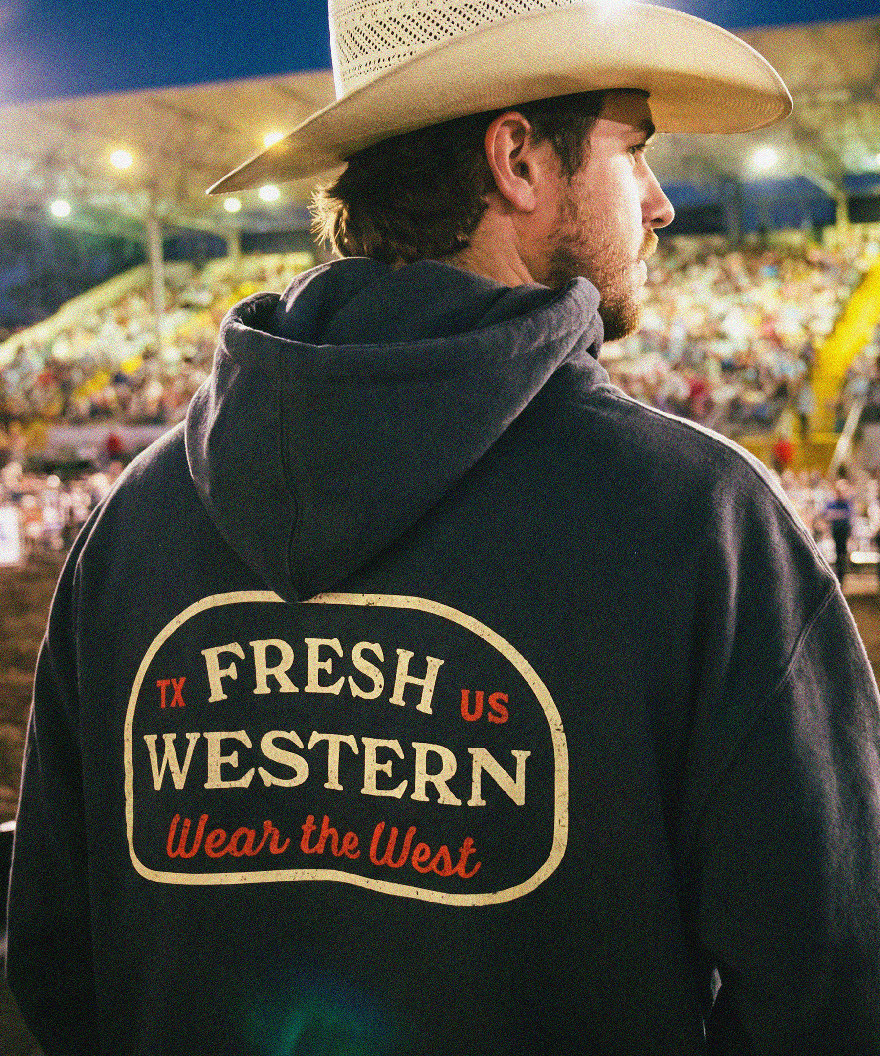 Fresh Western Charcoal Grey Hoodie on Cowboy at Rodeo. Hoodie features Wear the West motto