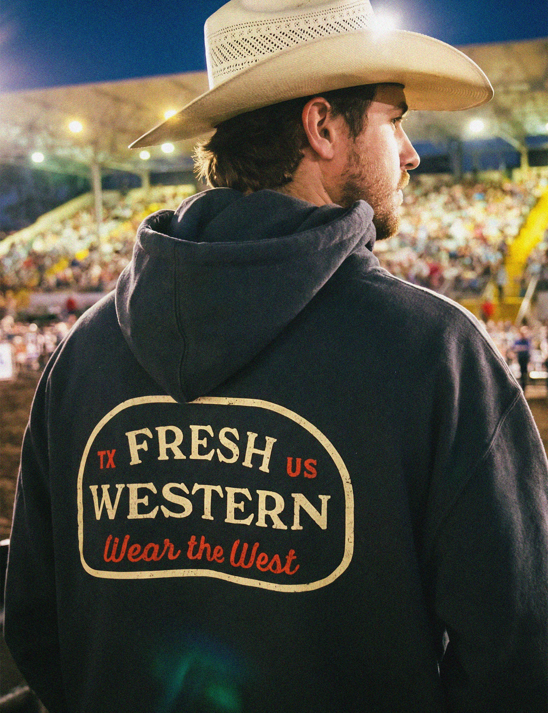 Fresh Western Charcoal Grey Hoodie on Cowboy at Rodeo. Hoodie features Wear the West motto
