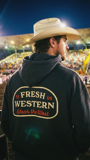 Fresh Western Charcoal Grey Hoodie on Cowboy at Rodeo. Hoodie features Wear the West motto